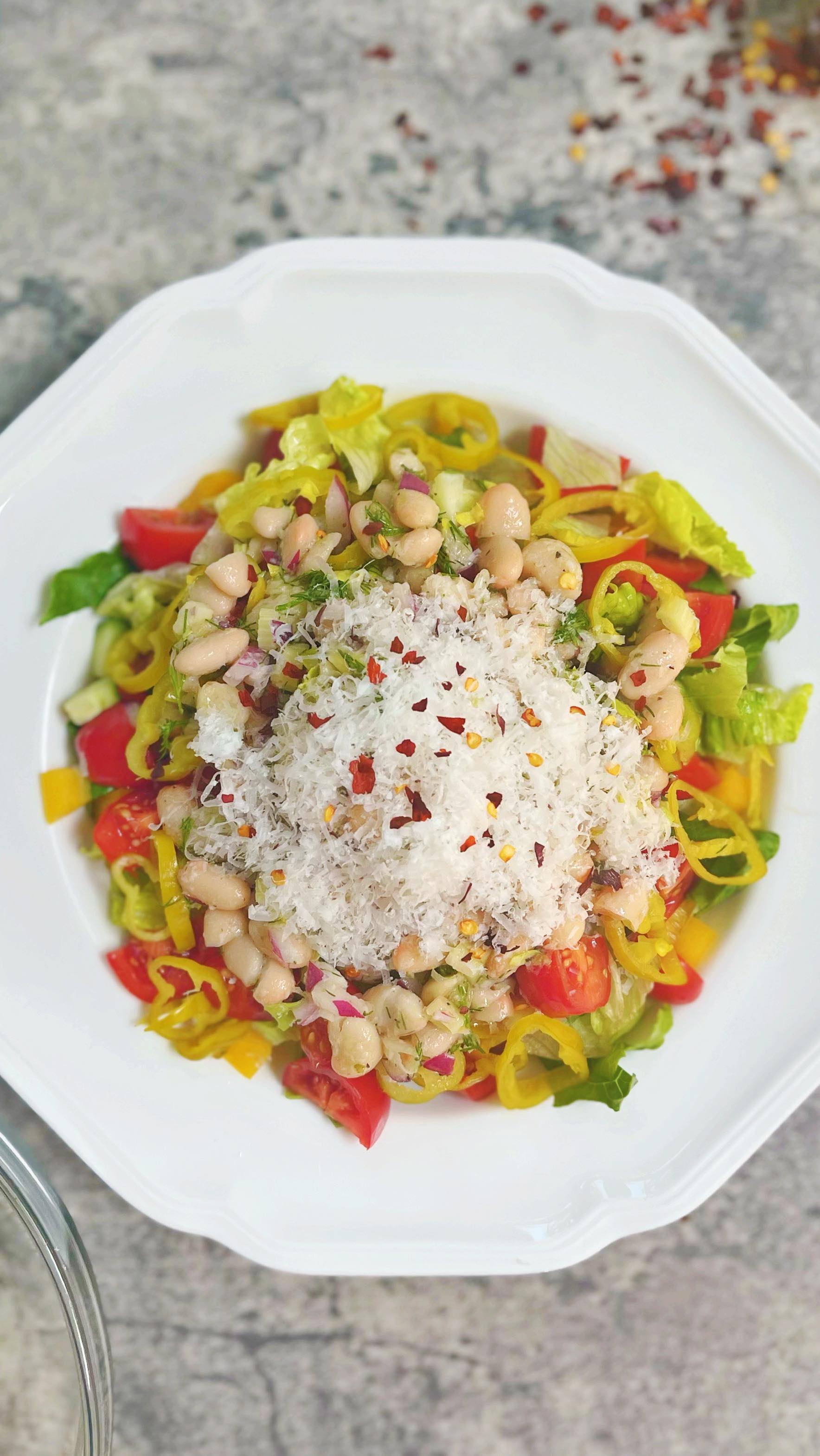 Follow @dinnerreinvented for more entree salads like this healthy take on the viral La Scala Chopped Salad that is apparently Kim Kardashian’s favorite salad. I subbed great northern beans for chickpeas and left out the salami, although I’m sure it would be delicious with that addition too! Full recipe below! 
2 cups romaine
1 cup ice urge
1/2 cup cherry tomatoes, quartered
1 Persian cucumber, diced
1/2 yellow bell pepper, diced
1/4 cup thinly sliced pepperocini pepper
1/4 cup red onion, diced
1/4 cup celery rib, plus frilly tops, diced
1/4 cup fresh dill, minced
1 can Great Northern beans, drained and rinsed
1 tsp red chili flake (optional)

For the vinaigrette:
1/2 cup grated Parmesan
1 tsp kosher salt
1/2 tsp pepper
1 tsp Dijon mustard
1 tsp garlic powder
1 tsp dried Italian seasoning
1/4 cup pepperocini juice from a jar of pepperocini 
3 tbsp champagne vinegar
1/2 cup extra virgin olive oil

#lascalachoppedsalad #kimkardashiansalad #kardashiandiet #lascala #chickpeasalad #viralsaladrecipes #viralreels #viralrecipes #foodblogger #weeknightdinner #wfhlunch #lunchideas #saladrecipe #veganrecipes #postworkoutmeal #mealprep #roniproter #dinnerreinvented